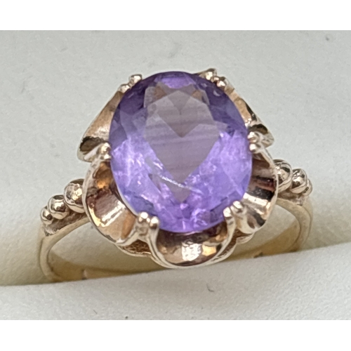 18 - A vintage 9ct gold amethyst set ring with central oval cut amethyst in a high scallop edge mount. St... 