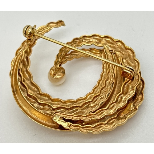 20 - A 9ct gold vintage style brooch set with a single cultured pearl. Intertwined semicircles in a plain... 