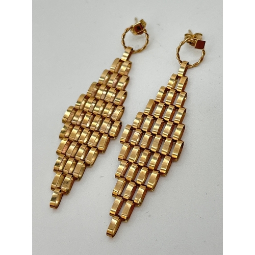 36 - A pair of 9ct gold drop style earrings. Diamond shaped drops made from gold links, suspended from a ... 