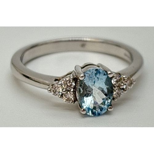 42 - A 9ct white gold diamond and blue topaz ring with central oval cut blue topaz. 3 small round cut dia... 