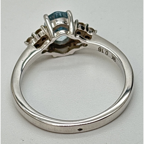 42 - A 9ct white gold diamond and blue topaz ring with central oval cut blue topaz. 3 small round cut dia... 