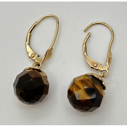 50 - A pair of 9ct gold and faceted tigers eye ball drop earrings with lever back posts. Approx. 3cm drop... 