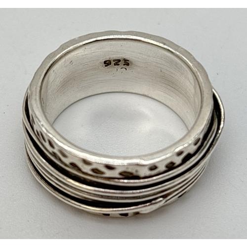 53 - A contemporary design silver band ring with 10mm thick pitted band and silver wire design to center ... 