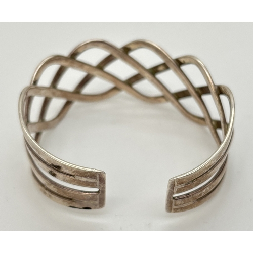 56 - A openwork Celtic design silver cuff bangle of twisted design. Approx. 2.75cm at widest point. Worn ... 