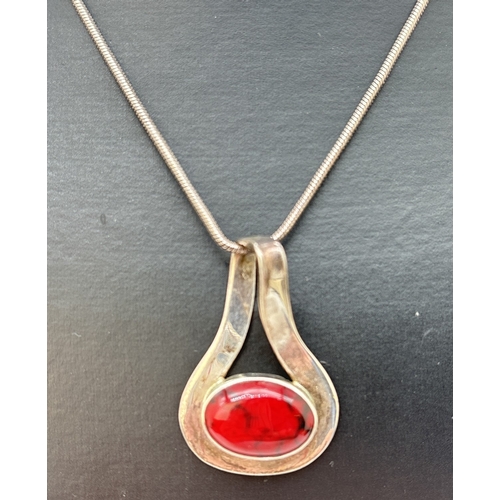 65 - A modern design twist style silver pendant set with an oval cabochon of red jasper, on a 16