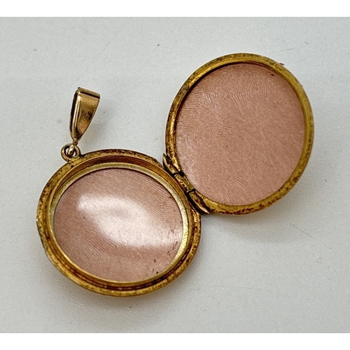 68 - A small circular 9ct gold locket with half floral engraved decoration to front. Hallmarked to back. ... 