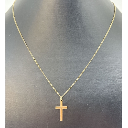 69 - A 9ct gold cross pendant with ridged detail, on an 18