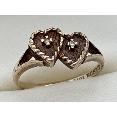 70 - A vintage 10K gold double heart ring. Each heart in brushed gold with rope design to edge and a sing... 