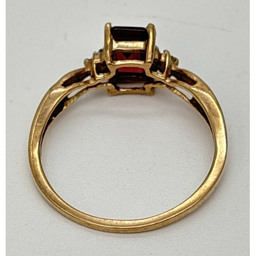 71 - A 9ct gold garnet and diamond dress ring. A central square cut garnet with 3 small round cut diamond... 