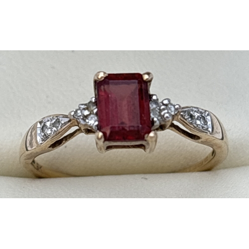 71 - A 9ct gold garnet and diamond dress ring. A central square cut garnet with 3 small round cut diamond... 