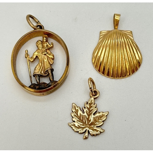 73 - 3 rolled gold pendants. A pierced work oval St. Christopher pendant, a maple leaf and a scallop shel... 