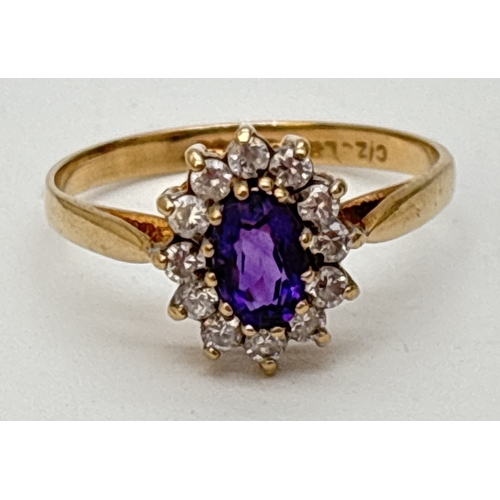 74 - A 9ct gold amethyst and Cubic Zirconia cluster style dress ring. A central oval cut amethyst surroun... 