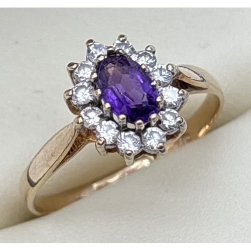 74 - A 9ct gold amethyst and Cubic Zirconia cluster style dress ring. A central oval cut amethyst surroun... 