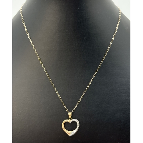 79 - A 9ct white and yellow gold open heart pendant on an 18