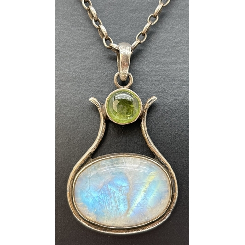 85 - A modern design large pendant set with a oval cabochon of moonstone and a round cut peridot. On a 16... 