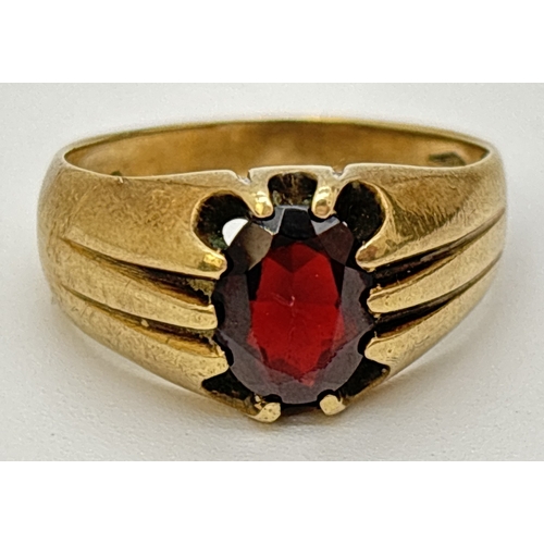 94 - A vintage 9ct gold men's signet ring set with an central oval cut garnet. Ridged design to shoulders... 