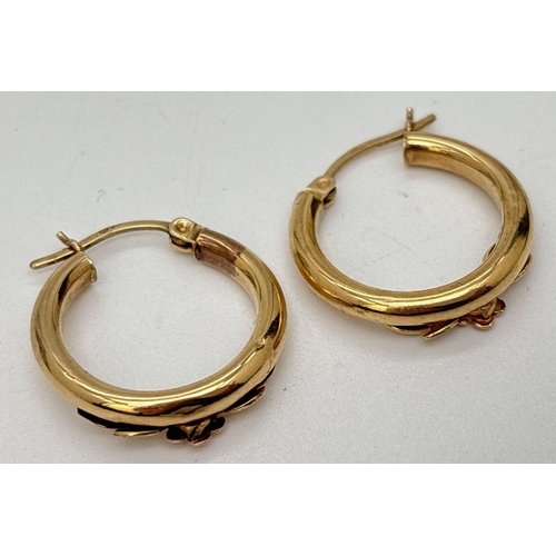 102 - A pair of 9ct gold hoop earrings with floral spray decoration. Marked 9K on posts. Approx. 2cm diame... 