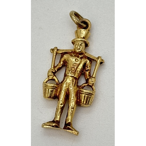 118 - A 14ct gold charm/pendant of a man in period dress with a shoulder yoke carrying buckets. Approx. 3c...