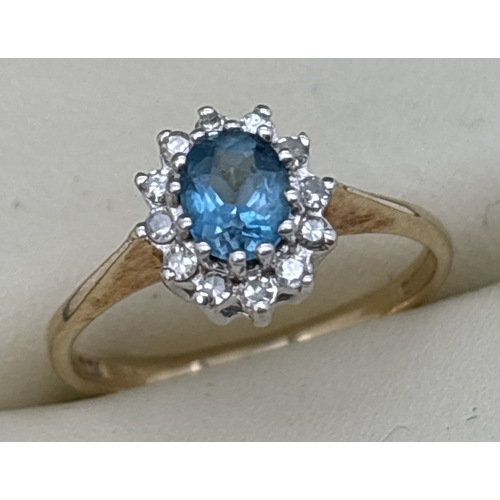 121 - A 9ct gold blue topaz and diamond cluster ring with central oval cut blue topaz. Surrounded by 12 ro... 