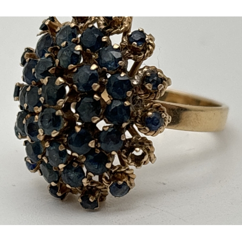 132 - A vintage 14ct yellow gold sapphire set cluster statement ring. 3 rows of round cut stones with 2 ce... 