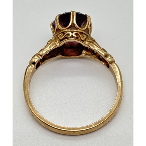 137 - A 9ct gold amethyst set dress ring with claw set stone and scroll decoration to mount and shoulders.... 