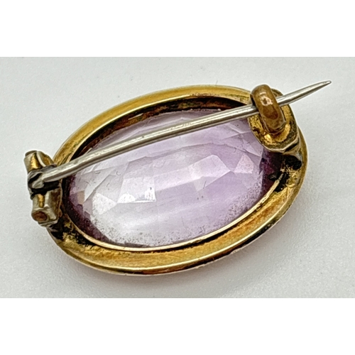  An antique yellow gold Rose de France amethyst brooch. Oval mount with floral engraved and ball deco... 