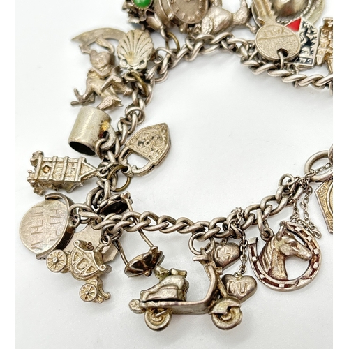  A vintage white metal charm bracelet with spring clasp, safety chain and 28 silver and white metal c... 