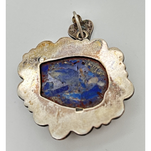 164 - A large silver ethnic style pendant with central floral carved lapis lazuli and heart shaped hanging... 