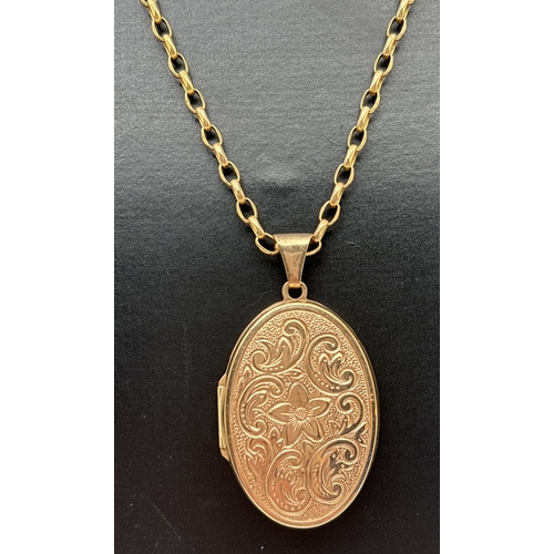 166 - A large oval 9ct gold locket with floral engraved decoration, on an 18