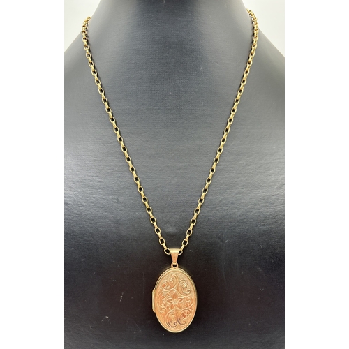 166 - A large oval 9ct gold locket with floral engraved decoration, on an 18