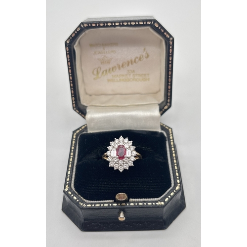 1001 - An 18ct yellow gold diamond and ruby cluster style ring. Central oval cut ruby surrounded by 22 roun... 