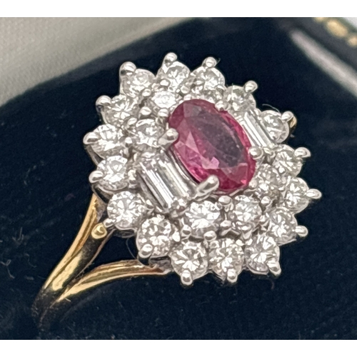 1001 - An 18ct yellow gold diamond and ruby cluster style ring. Central oval cut ruby surrounded by 22 roun... 