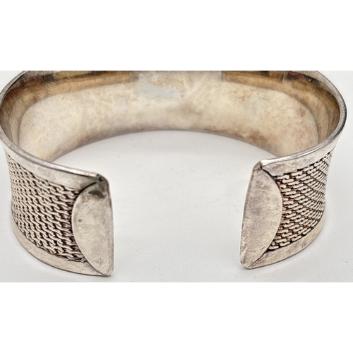 1006 - A 925 silver cuff bangle with S link decorated panel. Approx. 2.5cm wide. 925 stamped inside, Total ... 