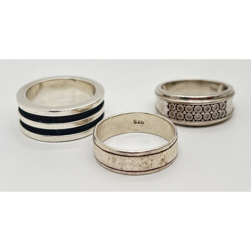 1007 - 3 silver Band rings. A plain band with channelled detail, a ring with double black band and a ring w... 