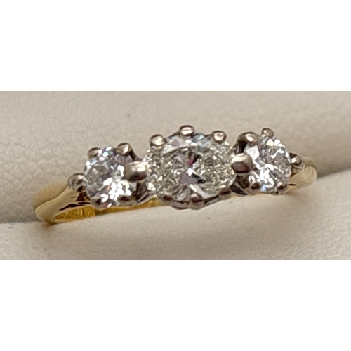 1018 - An 18ct gold and diamond trilogy style ring with central oval cut .50ct diamond and a round cut .15c... 