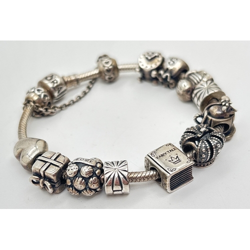 1019 - A silver charm bracelet by Pandora with 12 charm beads. Pandora and silver marks to all. Charms incl... 