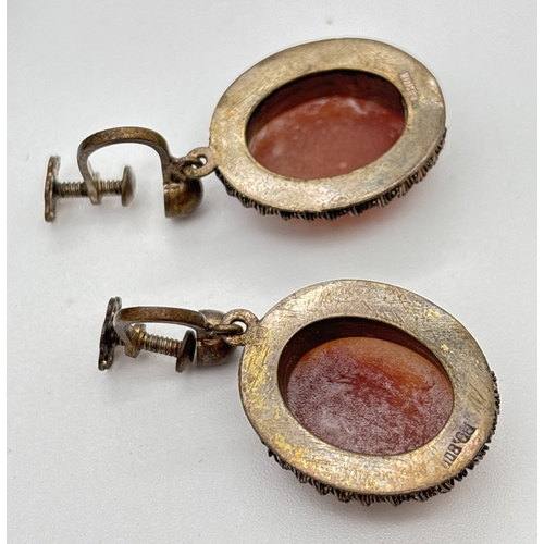 1109 - A pair of oval shaped cameo earrings with 800 silver mounts and screw back fixings. Each stamped 800... 