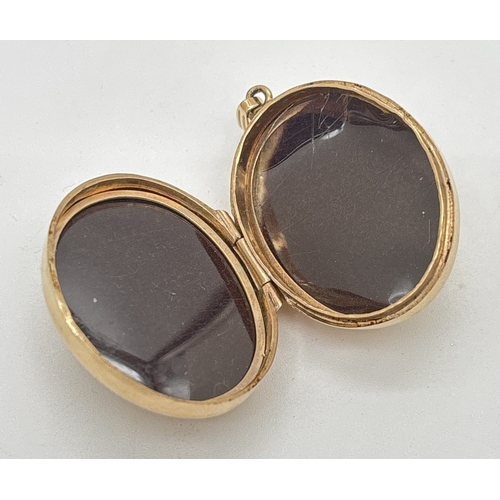 1093 - A large 9ct gold oval bulbous shaped locket with floral engraved pattern front and back. Hallmarked ... 