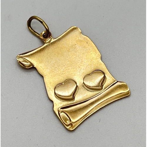 1098 - A 9ct gold scroll shaped pendant with 2 embossed love hearts. Stamped 375 on bale. Total weight appr... 