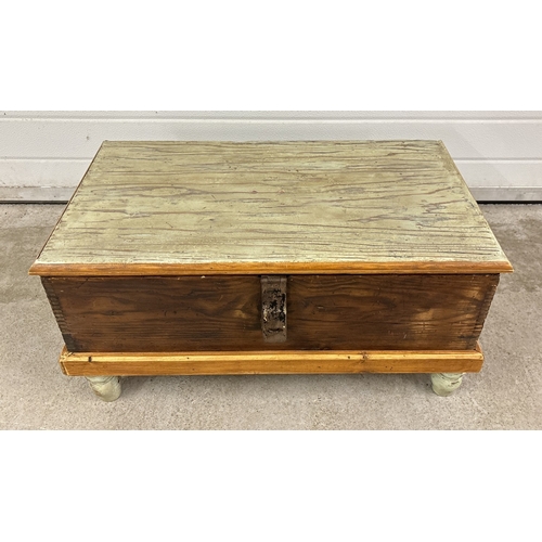 1388 - A vintage pine box with painted detail and metal latch, raised on 4 turned feet. Approx. 35 x 73 x 4... 