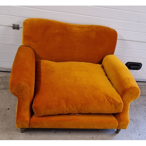 1392 - A modern wide seated low armchair with orange velvet upholstery and wooden feet. With fire labels, m... 