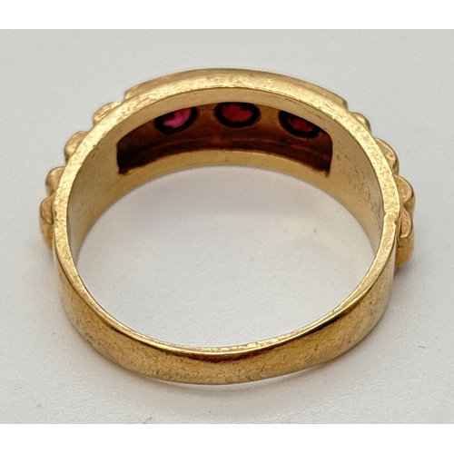 47 - A vintage 9ct gold band ring set with 3 round cut garnets and stepped detail to shoulders. Gold mark... 