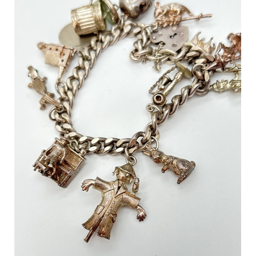 52 - A vintage silver charm bracelet with padlock, safety chain and 13 silver & white metal charms, some ... 