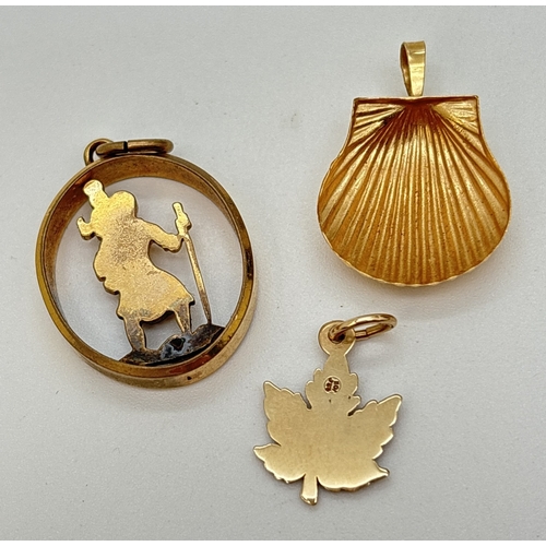 73 - 3 rolled gold pendants. A pierced work oval St. Christopher pendant, a maple leaf and a scallop shel... 