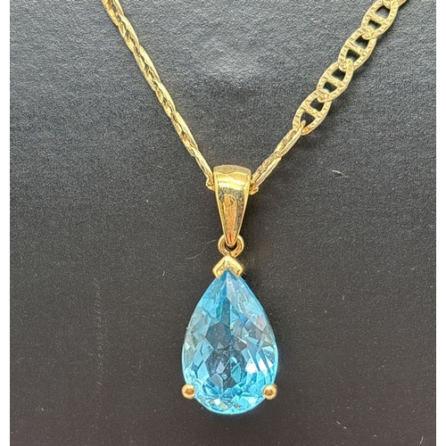 1042 - A silver gilt pendant necklace with teardrop cut blue topaz set pendant on a 22