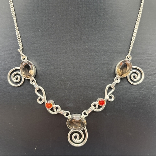 1086 - A silver fixed pendant necklace with scroll detail, set with 3 oval cut smoked quartz stones & 2 rou... 