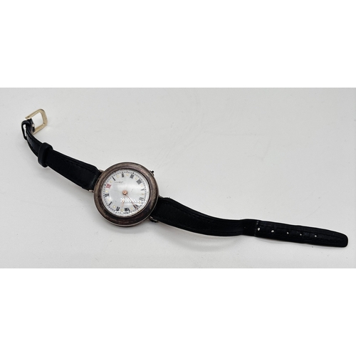 1146 - A silver cased vintage wristwatch with white enamel face and brown leather strap. Silver marks to in... 