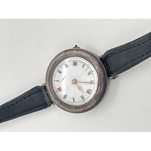 1146 - A silver cased vintage wristwatch with white enamel face and brown leather strap. Silver marks to in... 