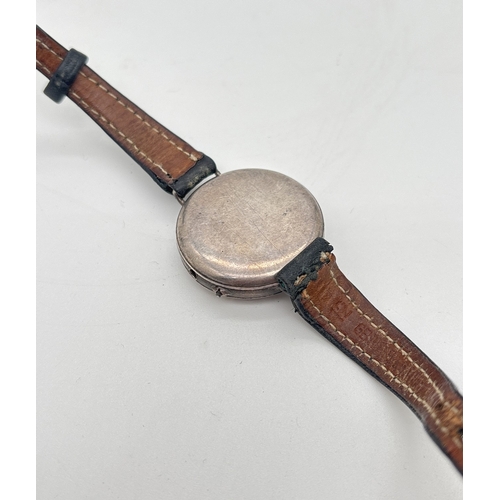 1146 - A silver cased vintage wristwatch with white enamel face and brown leather strap. Silver marks to in... 