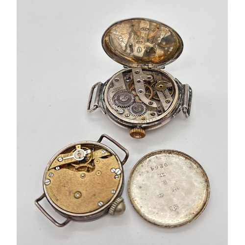 1148 - 2 antique silver wristwatches without straps. A round cased watch with white enamel face, black hour... 